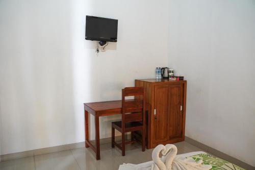 a room with a desk and a tv and a wooden cabinet at Wahyu Masari Homestay in Nusa Penida