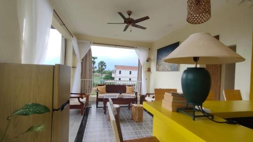 a living room with a yellow table and a ceiling fan at Homestay Yellow Natural House in Siem Reap