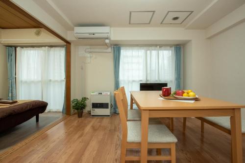 a living room with a dining room table with a plate of fruit on it at 札幌市中心部大通公園まで徒歩十分観光移動に便利なロケーションh602#11B in Sapporo