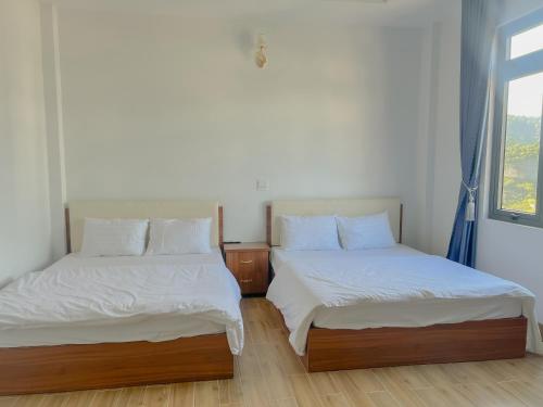 a bedroom with two beds and a window at HOTEL YÊN VIÊN in Hoat