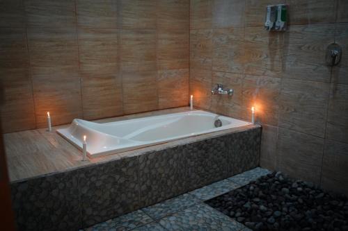 a bath tub in a bathroom with candles in it at Wahyu Masari Homestay in Nusa Penida