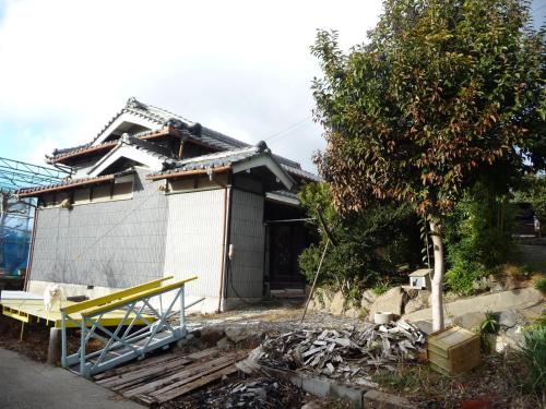 une maison avec un banc jaune devant elle dans l'établissement Japanese old house, à Takatsuki