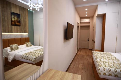 a bedroom with two beds and a mirror at IsraHotel Dushanbe in Dushanbe