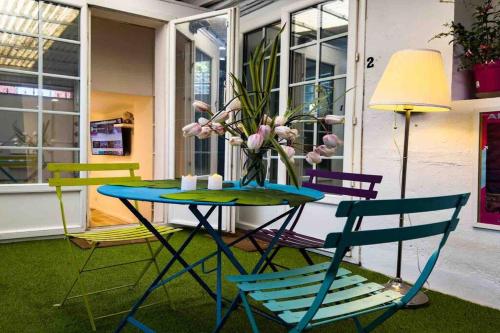 een tafel met stoelen en een vaas met bloemen erop bij Studio 1 Adorable studio neuf en bord de Marne 5kms Paris in Champigny-sur-Marne