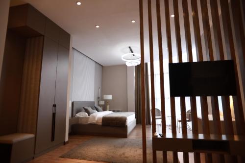 a bedroom with a bed and a flat screen tv at IsraHotel Dushanbe in Dushanbe