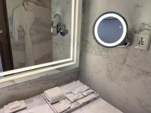 a bathroom with a mirror and a sink with towels at Le Meridien Amritsar in Amritsar