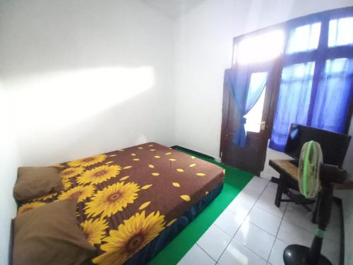 een slaapkamer met een bed met een zonnebloempit bij SPOT ON 93655 Home Stay Syariah Habibie in Sukabumi