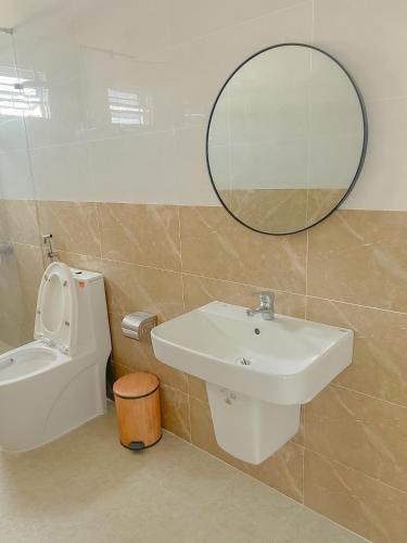 a bathroom with a sink and a mirror and a toilet at HOTEL YÊN VIÊN in Hoat