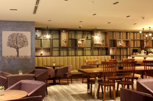 a restaurant with tables and chairs and a tree on the wall at Bof Hotels Business in Istanbul