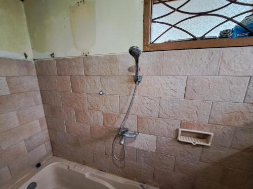 y baño con ducha y bañera. en OYO 93656 Villa Cassanova Syariah, en Garut