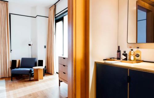 a bathroom with a sink and a desk with a chair at Shinola Hotel in Detroit