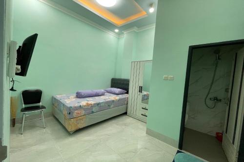 a bedroom with a bed and a chair and a mirror at Hotel O Homestay Purirano in Lepoleop