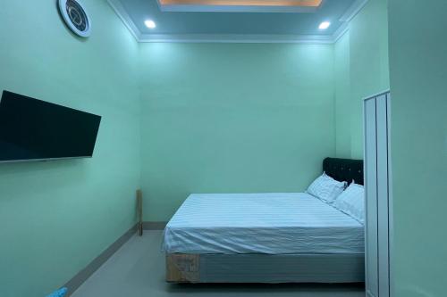 a bedroom with a bed and a flat screen tv at Hotel O Homestay Purirano in Lepoleop