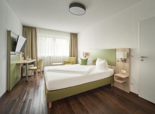 a hotel room with a bed and a desk and a table at Marias Inn - Bed & Breakfast in Garching bei München