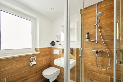y baño con aseo, lavabo y ducha. en Marias Inn - Bed & Breakfast en Garching bei München