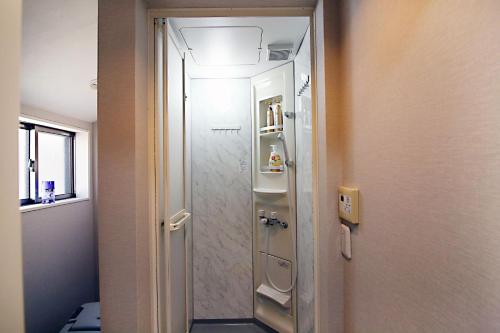 a bathroom with a walk in shower next to a door at SUN House free Wifi in Tokyo