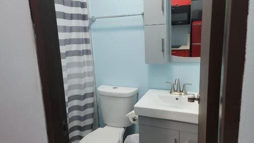 a bathroom with a white toilet and a sink at Spacious Studio walking distance to the Ocean, Unit 1 in Catano