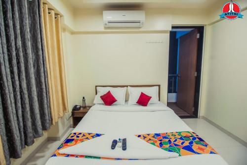 a bedroom with a bed with red pillows at Atithi Service Apartment in Pune