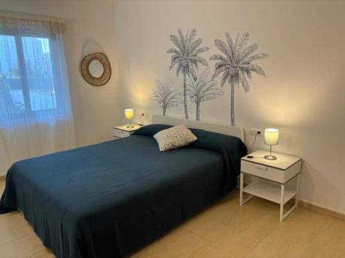 a bedroom with a blue bed with palm trees on the wall at APARTAMENTO Nº 8 SA PERDIU in Son Carrio