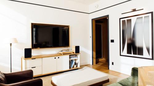 a living room with a tv on a white wall at Shinola Hotel in Detroit