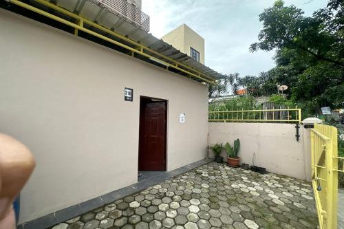 eine Tür zu einem Gebäude mit einer Veranda in der Unterkunft SPOT ON 93624 Damai 3 Guest House Syariah in Bandung