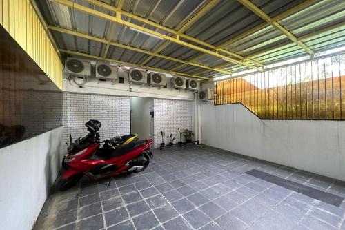 ein Zimmer mit einem Motorrad in einer Garage in der Unterkunft SPOT ON 93624 Damai 3 Guest House Syariah in Bandung