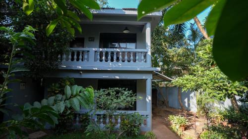 a house with a balcony in the yard at Sortby Stays, Vagator in Vagator