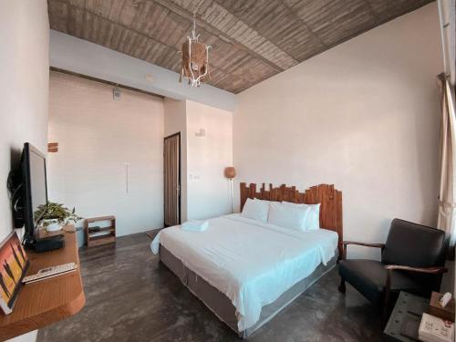 a bedroom with a bed and a desk and a chair at Lugo Hotel in Manzhou
