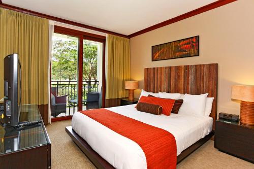 una camera con letto, TV e balcone di Ko Olina Beach Villas B204 a Kapolei