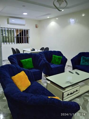 un soggiorno con tavolo e sedie blu di GL GUEST HOUSE ad Abomey