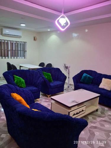 un soggiorno con divani blu e un tavolo di GL GUEST HOUSE ad Abomey