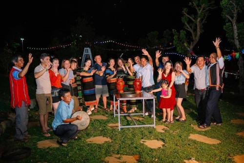 un grupo de personas posando para una foto por la noche en Khu Du lịch Nông trại Hải Đăng trên núi, en Gia Nghĩa