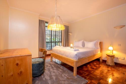 a bedroom with a bed and a window at Riverside Hidden Oasis By YourHost 3 Bed in Nairobi