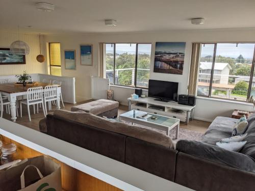 a living room with a large couch and a table at The Castle - Goolwa Beach in Goolwa South