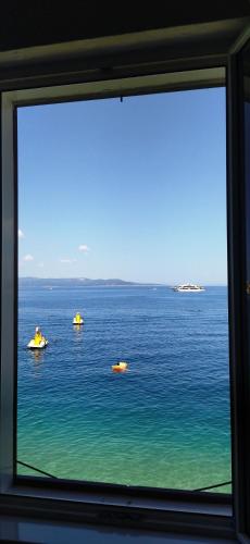 a view from a window of boats in the water at Beach rooms Riviera - Žuta Kuća in Makarska