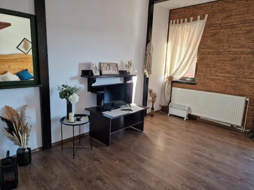 a living room with a black desk and a window at Pensiunea Hanul Dorului in Drumu Carului