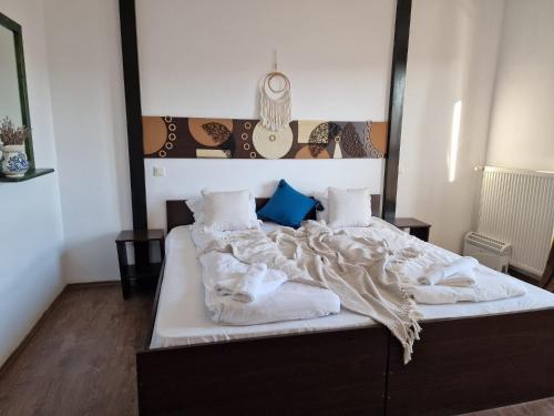 a bedroom with a bed with white sheets and pillows at Pensiunea Hanul Dorului in Drumu Carului