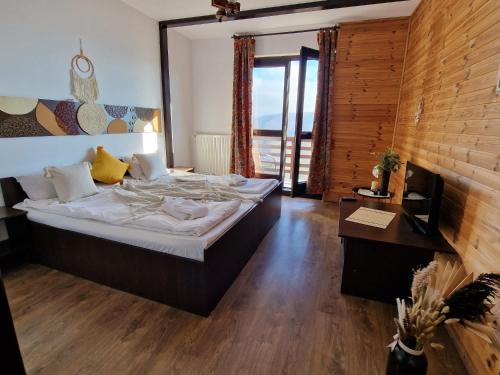 a bedroom with a large bed and a wooden wall at Pensiunea Hanul Dorului in Drumu Carului