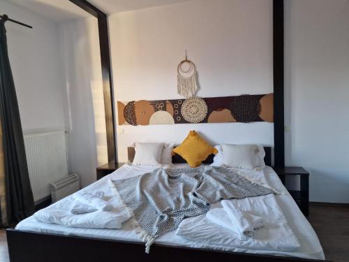 a bedroom with a large bed with white sheets and pillows at Pensiunea Hanul Dorului in Drumu Carului