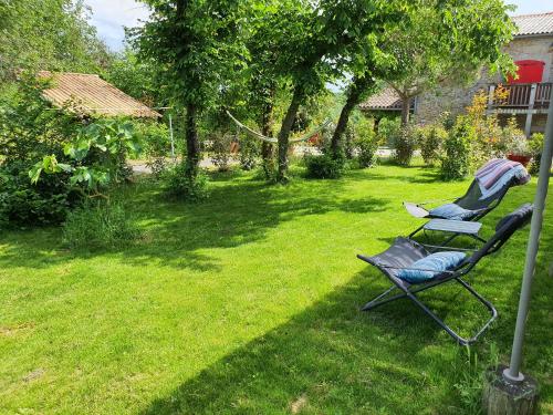 two chairs sitting in the grass in a yard at Les pieds en éventail in Lignairolles