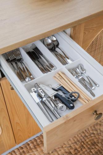 a drawer in a wooden cabinet filled with silverware at Gili Boho Villas - Aesthetic Private Pool Villas in Gili Trawangan