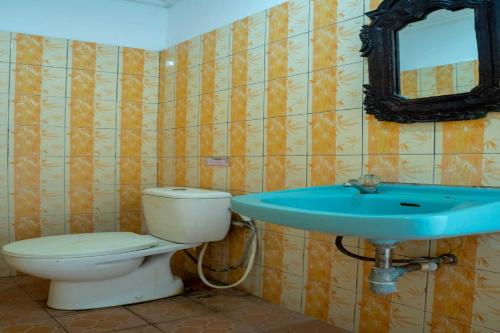 OYO 93604 Hepi Bungalow Lovina في Panji: حمام مع مرحاض ومغسلة