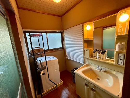 uma pequena casa de banho com um lavatório e um frigorífico em ゲストハウス 畔（hotori） 