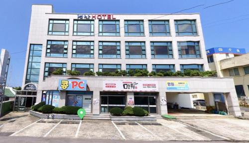 a building with a parking lot in front of it at Seongsan Motel in Seogwipo