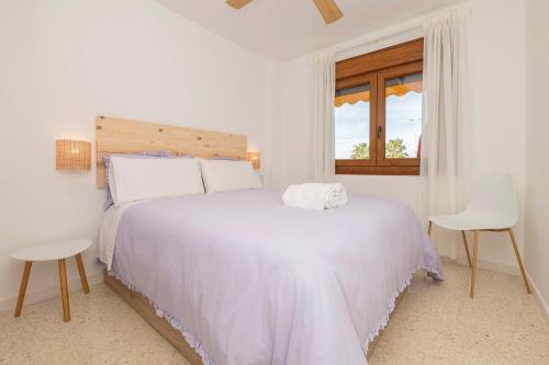 een witte slaapkamer met een wit bed en een raam bij Ventana a Doñana in Sanlúcar de Barrameda