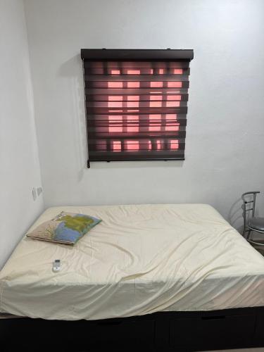 a bed in a white room with a window at Departamento Diegos cabo in Cabo San Lucas