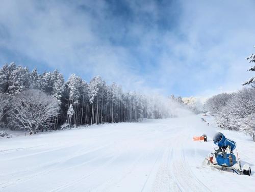 a snowmobile is parked on a snow covered road at Mineyama Kogen Hotel Relaxia in Kamikawa