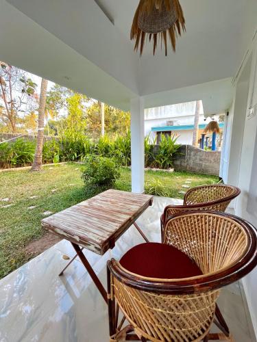 a porch with a wooden table and chairs at Point Break Varkala in Varkala