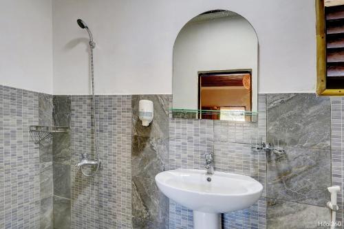 a bathroom with a sink and a mirror at Fleurs d'Ylang in Nosy Be