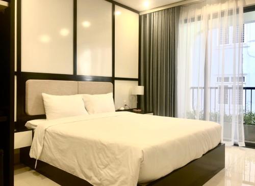 a bedroom with a large white bed and a window at Ana's House in Quy Nhon